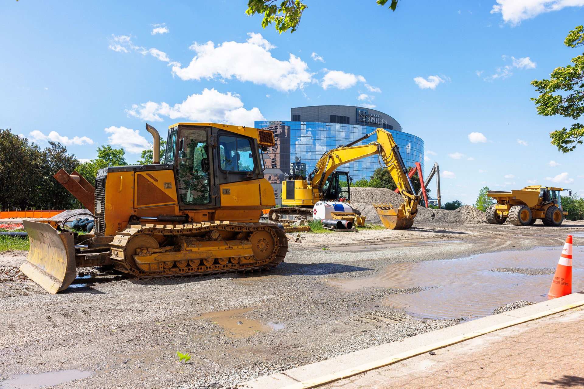 Road widening and road scraper working in financial district. Excavator digging and destructing ground for new building complex in Newport News, VA